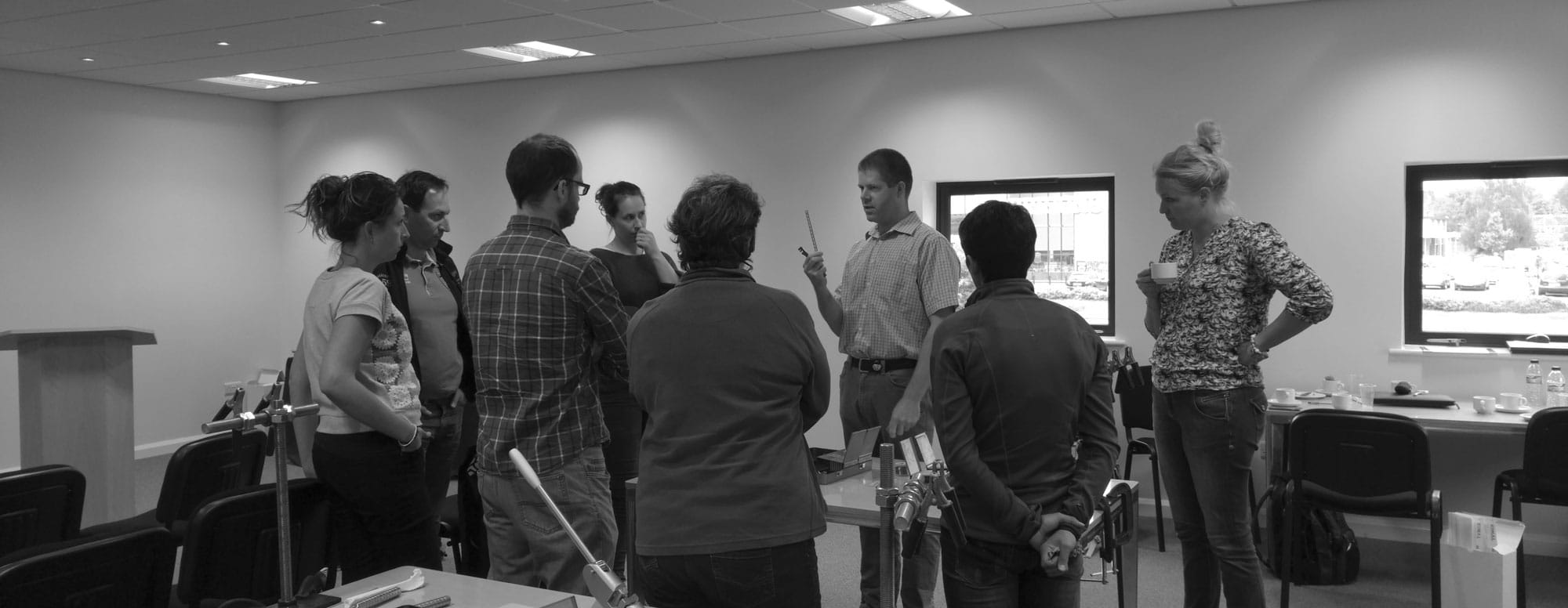 People standing watching an instructor teach in a training room