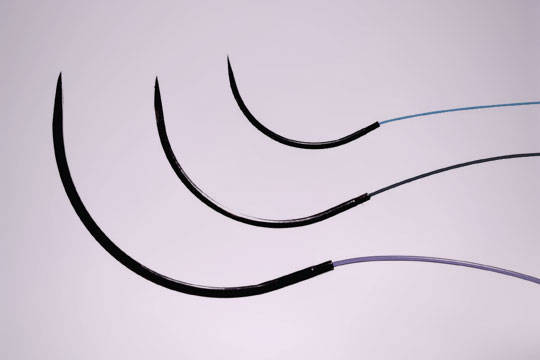 Close-up of 3 black suture needles